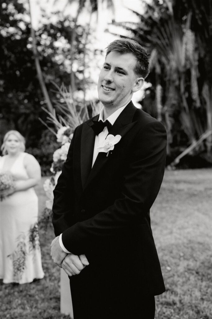 Groom looking at bride walking down the aisle